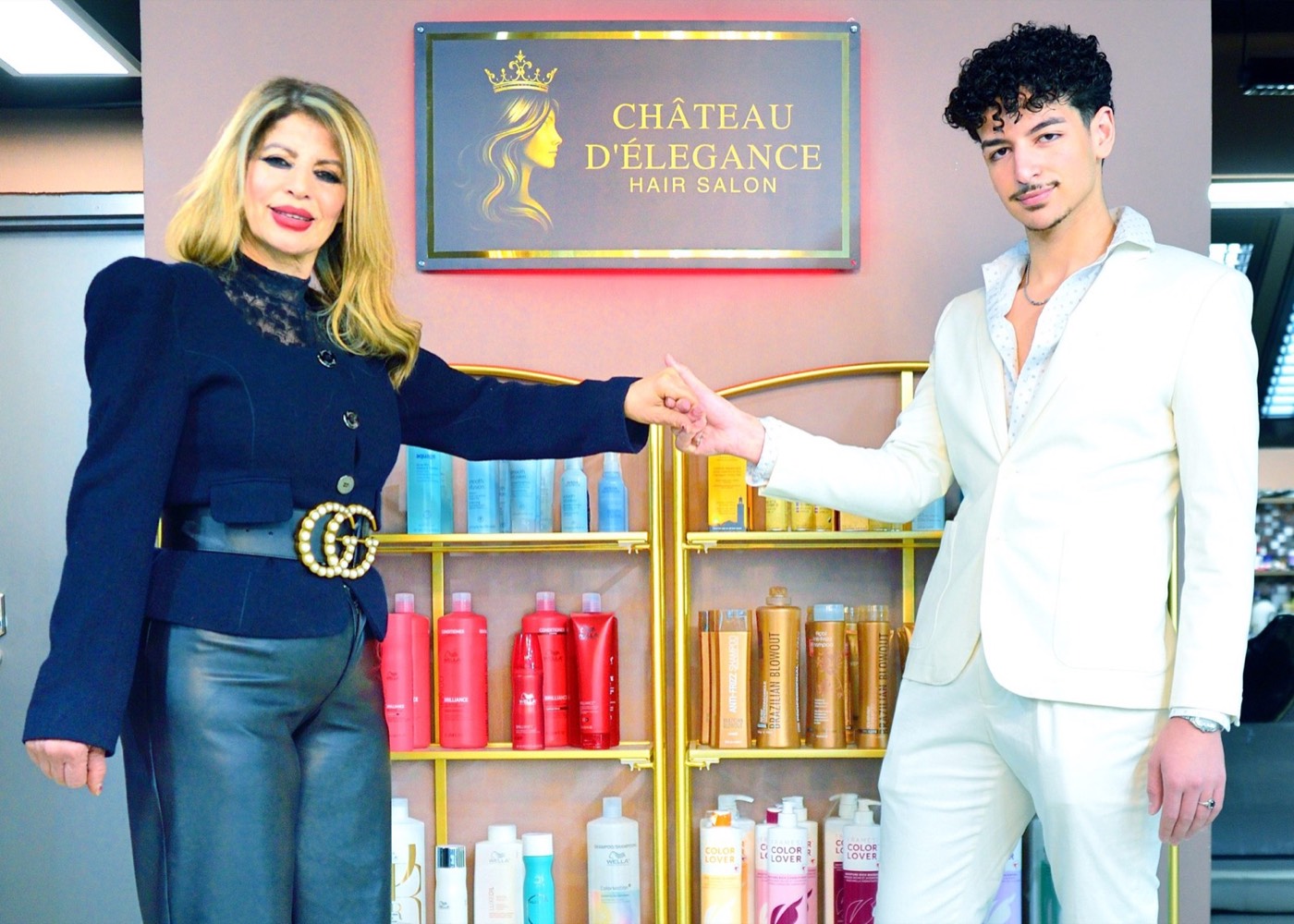 Mona Zouhir and team member in front of the Chateau D'Elegance sign